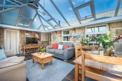 a living room with a glass ceiling with a couch and a table at Laity Vean Hideaway - 2 Pets Allowed - Free Parking & WiFi in Carbis Bay