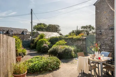 a garden with a table and chairs and a fence at Laity Vean Hideaway - 2 Pets Allowed - Free Parking & WiFi in Carbis Bay