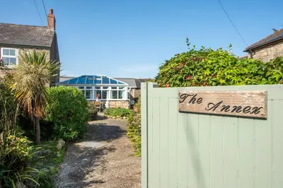 a sign on a fence in front of a garden at Laity Vean Hideaway - 2 Pets Allowed - Free Parking & WiFi in Carbis Bay