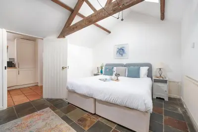 a bedroom with a large white bed and a doorway at Laity Vean Hideaway - 2 Pets Allowed - Free Parking & WiFi in Carbis Bay