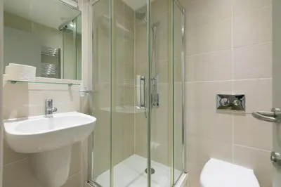 a bathroom with a sink and a glass shower at Puffins in St Ives