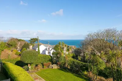 a view of a house with the ocean in the background at Puffins in St Ives