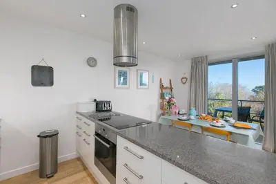 a kitchen with white cabinets and a counter top at Puffins in St Ives