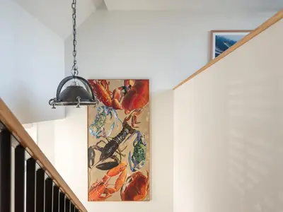a painting hanging on a wall next to a staircase at Church Rooms in Port Isaac