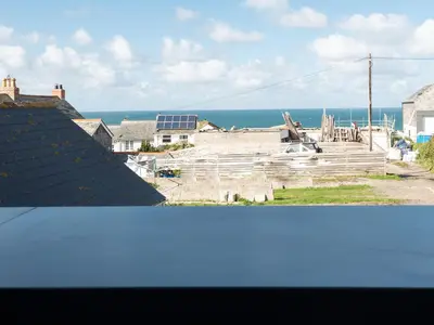 a view of the ocean from the roof of a house at Church Rooms in Port Isaac