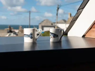 two coffee mugs sitting on top of a table at Church Rooms in Port Isaac