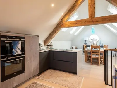 a kitchen with a stove top oven next to a table at Church Rooms in Port Isaac