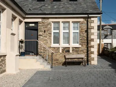 a brick house with a bench in front of it at Church Rooms in Port Isaac