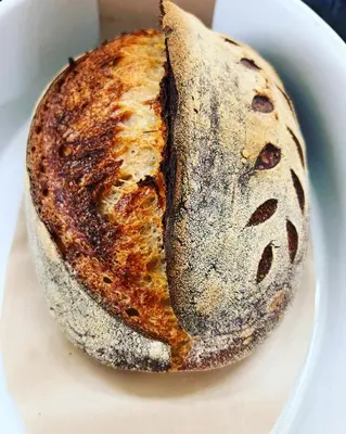 a loaf of bread sitting on a white plate at The Cottage Bed & Breakfast in Polperro