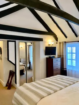 a bedroom with a large bed and a tv at The Cottage Bed & Breakfast in Polperro
