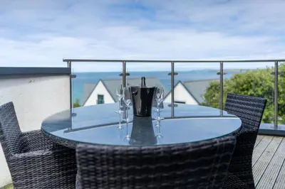 a table with wine glasses on top of a balcony at Porthminster Mews in St Ives