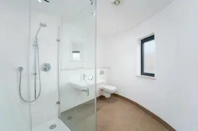 a bathroom with a shower and a toilet and a sink at Porthminster Mews in St Ives