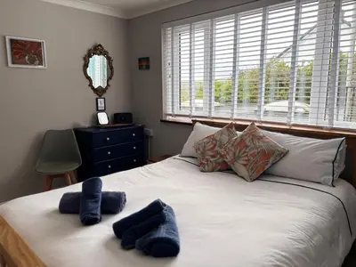 a bedroom with a bed with two blue towels on it at Stonecroft in Praa Sands
