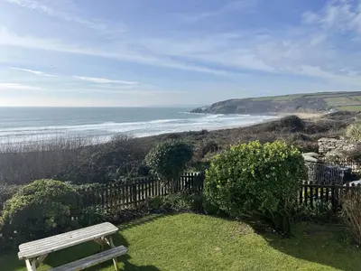 a bench sitting on the grass near the beach at Stonecroft in Praa Sands