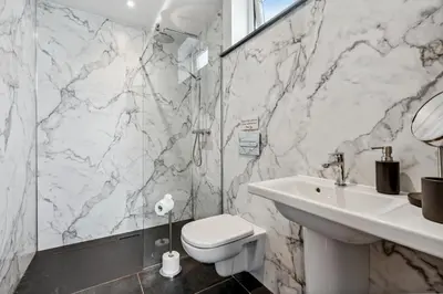 a white bathroom with a toilet and a sink at Trewethen Cottage Barn 1 near Port Isaac in Port Isaac