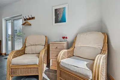 two wicker chairs and a dresser in a room at Trewethen Cottage Barn 1 near Port Isaac in Port Isaac