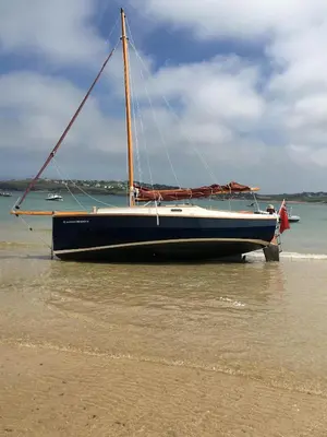 a sail boat sitting on the shore of a beach at Trewethen Cottage Barn 1 near Port Isaac in Port Isaac