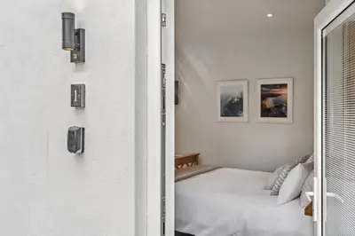 a white bedroom with a bed and a window at Trewethen Cottage Barn 1 near Port Isaac in Port Isaac
