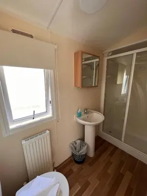 a bathroom with a toilet and a sink and a shower at Contemporary Caravan at Newquay Holiday Park in Newquay