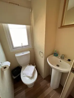 a small bathroom with a toilet and a sink at Contemporary Caravan at Newquay Holiday Park in Newquay