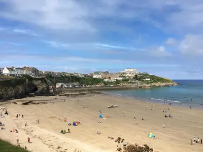 a group of people on a beach near the ocean at Contemporary Caravan at Newquay Holiday Park in Newquay