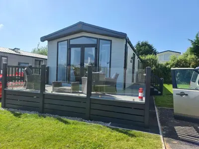 a house with a large glass window on the grass at Mawgan Pads Padstow in Padstow