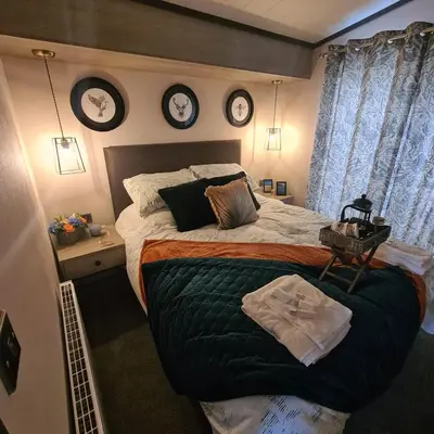 a bedroom with a large bed with clocks on the wall at Mawgan Pads Padstow in Padstow