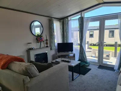 a living room with a couch and a television at Mawgan Pads Padstow in Padstow