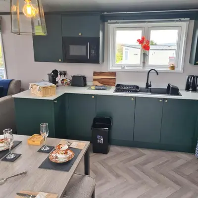 a kitchen with blue cabinets and a table and a sink at Mawgan Pads Padstow in Padstow