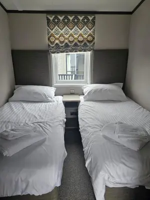 two beds in a small room with a window at Mawgan Pads Padstow in Padstow