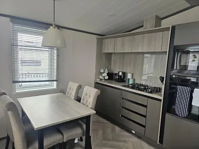 a kitchen with a table and chairs and a stove at Mawgan Pads Padstow in Padstow