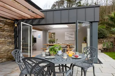 a patio with a table and chairs and a kitchen at Beach Cottage and The Lobster Pot in St. Agnes