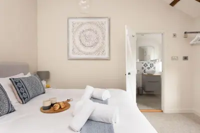 a white bed with a tray of food on it at Beach Cottage and The Lobster Pot in St. Agnes
