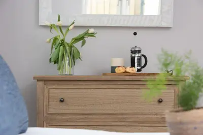 a wooden dresser with a plant on top of it at Beach Cottage and The Lobster Pot in St. Agnes