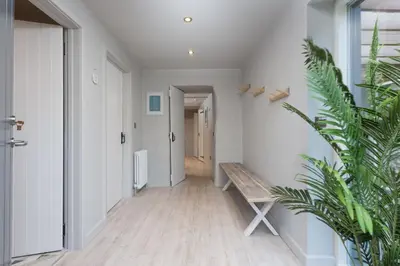 a hallway with a wooden bench in a house at Beach Cottage and The Lobster Pot in St. Agnes
