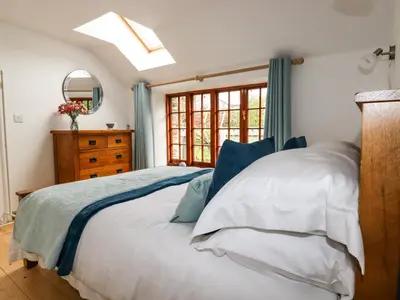 a bedroom with a bed and a skylight at Little Orchard Barn in St Austell