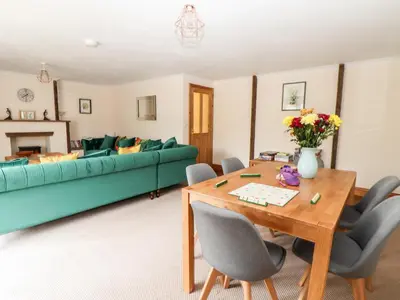 a living room with a table and a green couch at Wheal ProsperThe West Dry in St Austell