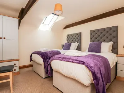 two beds in a room with purple blankets at Wheal ProsperThe West Dry in St Austell