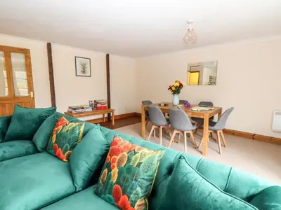 a living room with a green couch and a table at Wheal ProsperThe West Dry in St Austell