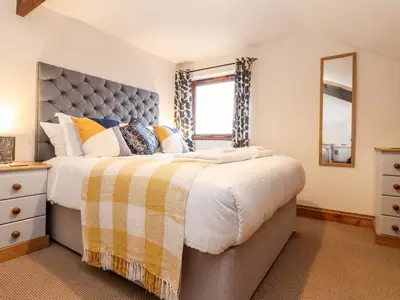 a bedroom with a large bed and a window at The KilnsThe West Dry in St Austell