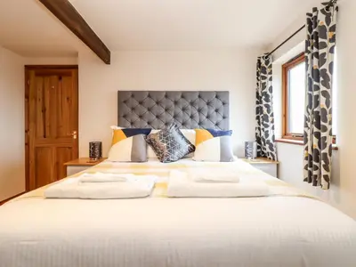 a bedroom with a large white bed with two pillows at The KilnsThe West Dry in St Austell