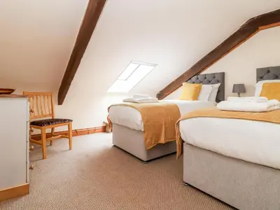 two beds in a attic bedroom with a skylight at The KilnsThe West Dry in St Austell