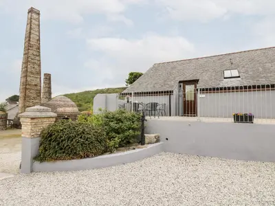 a house with a chimney and a building at The KilnsThe West Dry in St Austell