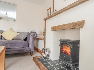 a living room with a stove and a couch at Water WheelsThe West Dry in St Austell