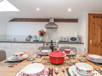 a kitchen with a table with plates and wine glasses at Water WheelsThe West Dry in St Austell