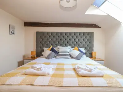 a bedroom with a large bed with two towels at Water WheelsThe West Dry in St Austell