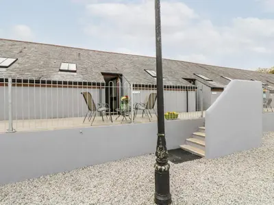 a house with a white fence and a porch at Water WheelsThe West Dry in St Austell