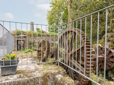 a metal fence next to a garden with flowers at Water WheelsThe West Dry in St Austell