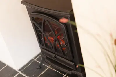 a fireplace in a kitchen with the door open at RiversideThe West Dry in St Austell