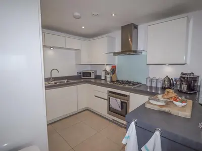 a kitchen with white cabinets and a counter top at Sky in St Ives